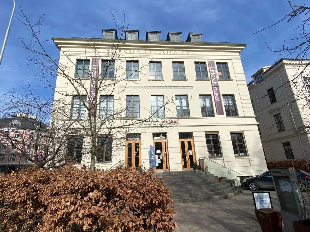 Litteraturhusets lyse, pussede fasade i tre etasjer med inskripsjonen Oslo Lærerskole over vinduene og Litteraturhuset-bannere ved inngangen. – bilde 1