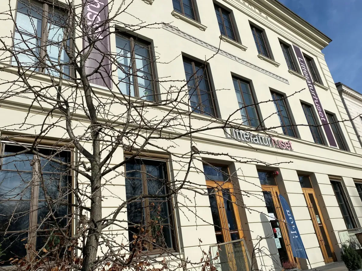 Litteraturhusets lyse, pussede fasade i tre etasjer med inskripsjonen Oslo Lærerskole over vinduene og Litteraturhuset-bannere ved inngangen. – bilde 2