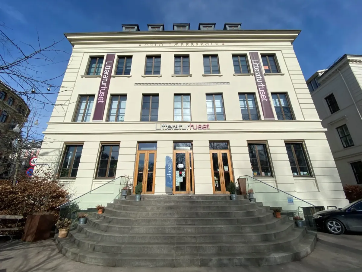 Litteraturhusets lyse, pussede fasade i tre etasjer med inskripsjonen Oslo Lærerskole over vinduene og Litteraturhuset-bannere ved inngangen. – bilde 4