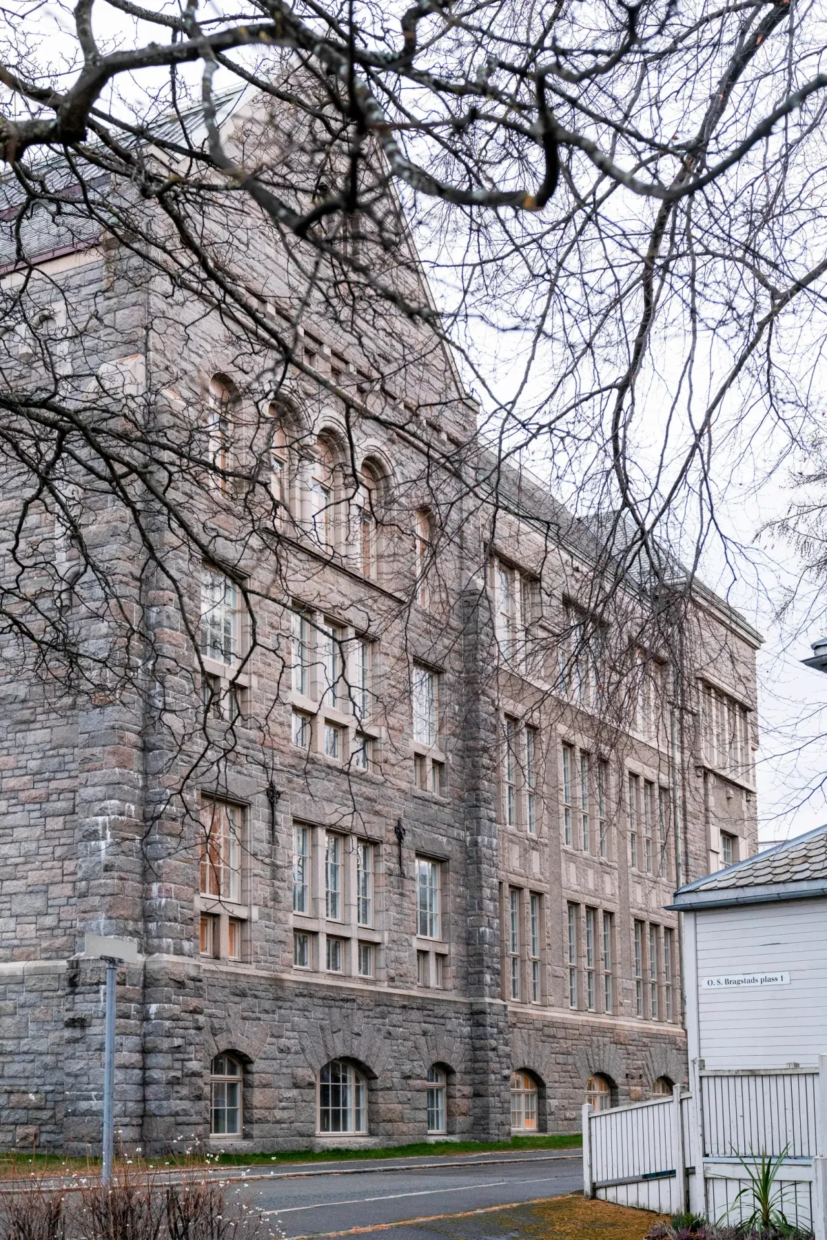 Detalj av et restaurert buevindu med hvit ramme innfelt i en grovhugget granittfasade. – bilde 5
